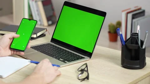 Man using laptop and smartphone with green screen, close-up. Online Educati.. Stock Footage 272219690