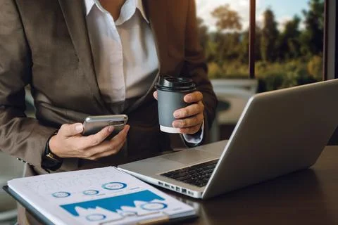 Man using laptop and typing on laptop and holding coffee cup Stock Photos