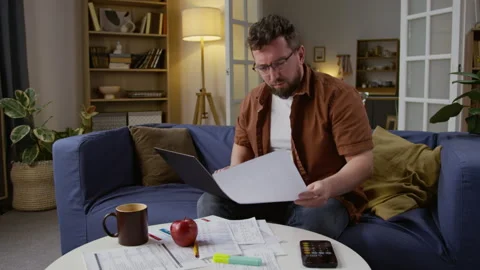 Man using Laptop and Working with Finances Documents on Table Stock Footage 327683639