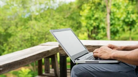 Man using a laptop on the balcony. Stock Photos