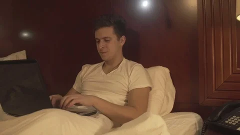 Man using laptop on the bed in home interior. 스톡 동영상 73984352