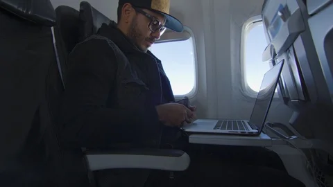 Man using laptop to buy something online while traveling on plane Stock Footage 122184415