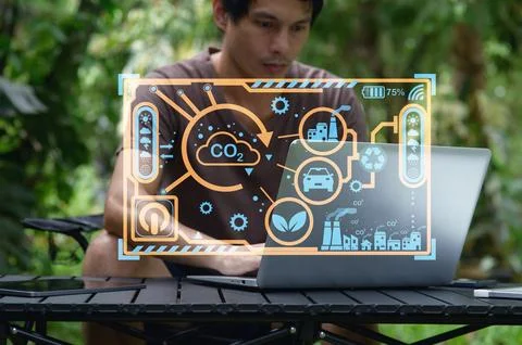 Man Using Laptop with CO2 Emission Data and Eco-Friendly Graphics 写真素材
