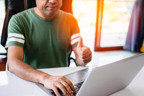 A man is using a laptop to communicate with the Internet. Freelance learnin.. Stock Photos