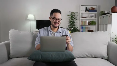 Man using laptop computer holding credit card for online shopping and payment Stock Footage 167940729