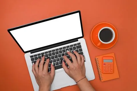 Man using laptop computer on orange background. Stock Photos