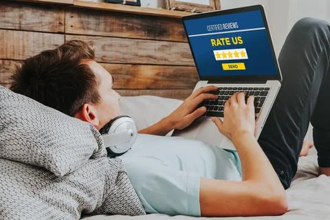 Man using a laptop computer to rate products and services on internet. Stock Photos