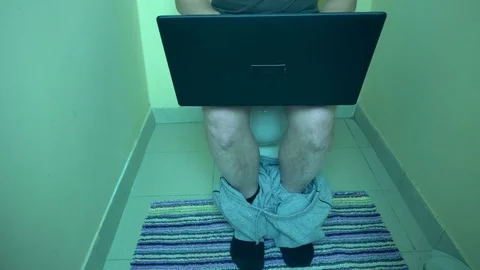 Man using laptop computer in the toilet Stock Footage 72111762