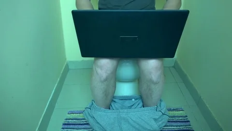 Man using laptop computer in the toilet Stock Footage 72111887