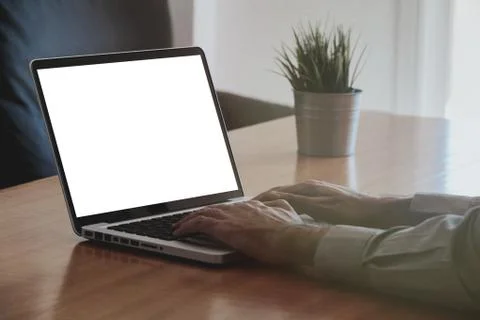 Man using a laptop computer with white blank screen. Stock Photos