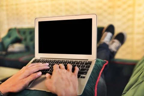 Man using a laptop on a couch Stock Photos