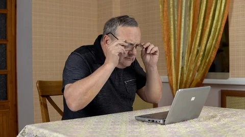 Man is using a laptop for the first time. The old man hardly uses a laptop hard 库存影片 124667097