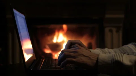 Man using laptop in front of fireplace Video stock 57969366