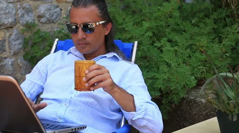 Man using laptop at the garden and drinking coffee Stock Footage 53281476