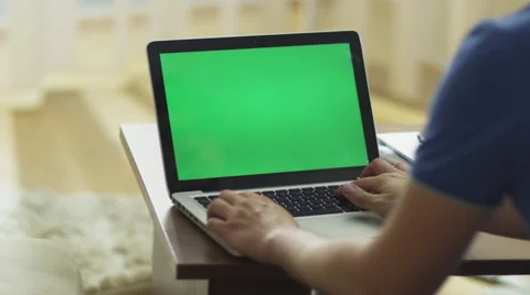 Man Using Laptop with Green Screen in Living Room Stock Footage