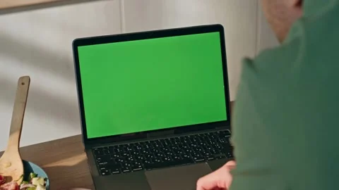 Man using a laptop with a green screen in a modern kitchen Stock-Footage 334137068