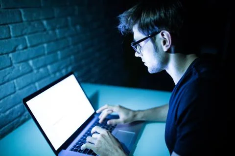 Man using laptop in the night with white screen copy space Foto stock