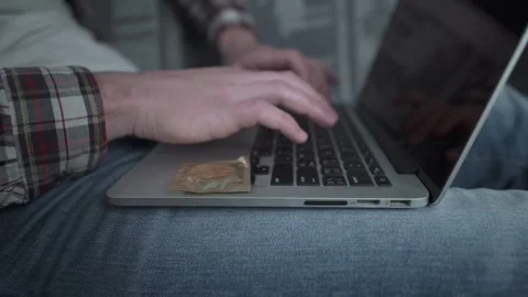 Man using laptop for online dating with a condom nearby. Concept of safe sex and Stock Footage 329280495