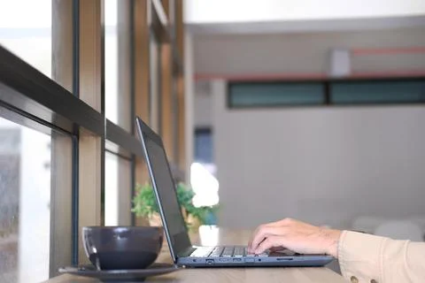 Man using laptop online seated at office table Stock Photos