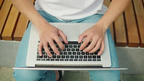 Man using laptop outdoor top view. Young guy working remotely on computer in Stock Footage 201276113