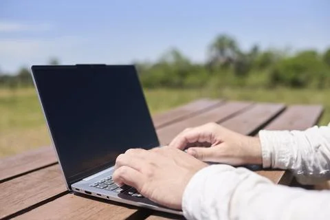 Man using a laptop outdoors, digital nomad working remotely while traveling Foto stock
