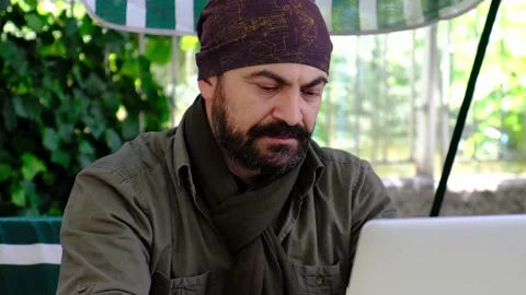 Man using laptop outdoors looking at camera and smiling Stock Footage 145257159