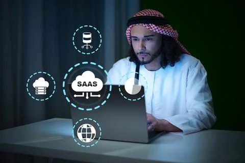 Man using laptop for SaaS solutions in a modern workspace at night Foto stock