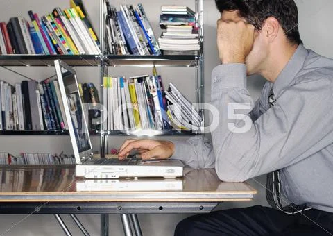 Man using laptop, side view Stock Photos