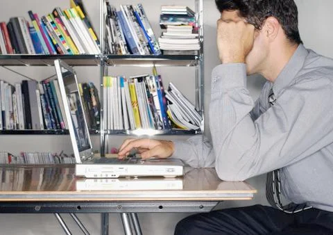Man using laptop, side view Stock Photos