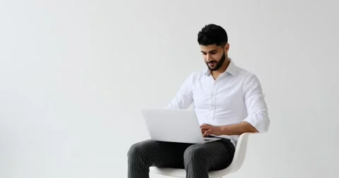 Man using laptop sitting against white background Stock-Footage 196078219