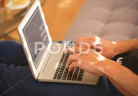 Man using laptop on sofa in living room Mockup PSD-Vorlage