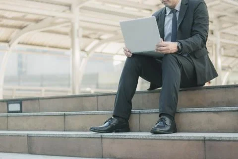 Man using laptop on stair. Stock Photos