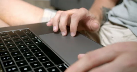 Man using a laptop trackpad while scrolling website and browsing the internet Stock Footage 170635429
