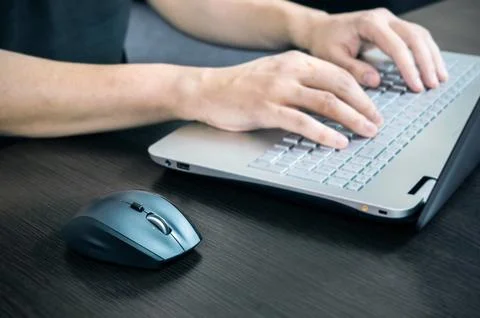 Man using laptop with white keyboard. Working in office Stock Photos