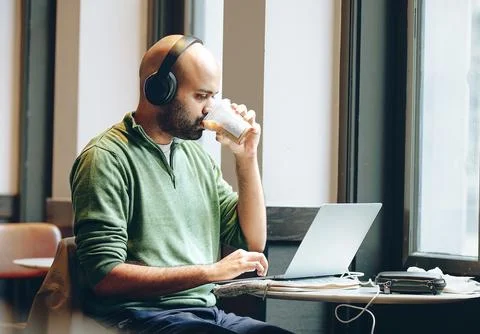 A man using a laptop by the window Stock Photos