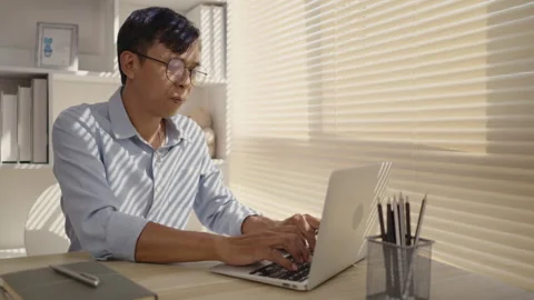 Man using laptop to work on table in office, Press the keyboard on the laptop Stock Footage 263467189