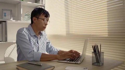 Man using laptop to work on table in office, Press the keyboard on the laptop Stock Footage 263467402