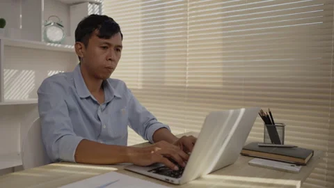 Man using laptop to work on table in office, Press the keyboard on the laptop Stock Footage 263478574