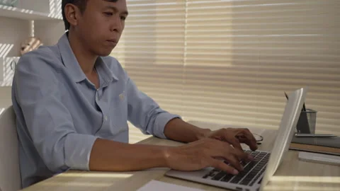 Man using laptop to work on table in office, Press the keyboard on the laptop Stock Footage 263479045