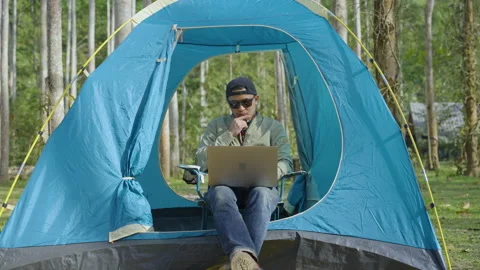 The man using laptop for working while outdoor camping  Vídeos de archivo 232589628