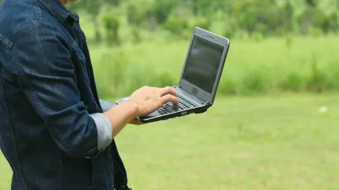 Man using a laptop works in the forest. Stock Footage 136523906