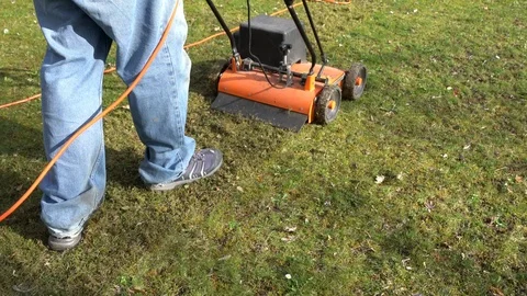 A man using a lawn aeratorin the garden Stock Footage 127020123