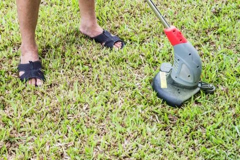 Man using lawn mower Stock Photos