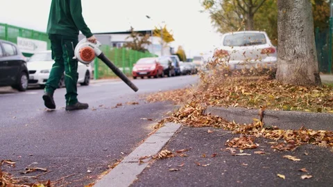 Man using leaf blower low angle Stock Footage 118962679