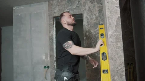 Man using a level tool to ensure wall alignment while working Video stock 317380527