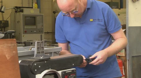 Man using a linisher / belt grinder Stock Footage 46631982