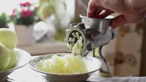 A man using a manual meat grinder in the home kitchen. Stock Footage 152356326