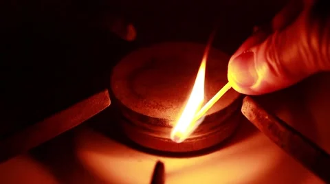 Man using a match ignites the gas on a gas stove in the dark Stock Footage 49567006