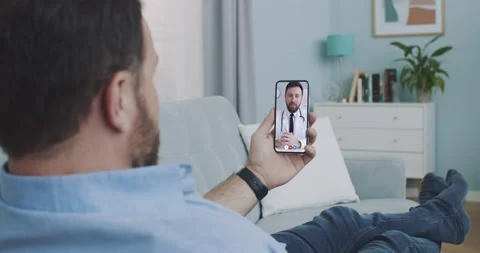 Man using medical app on smartphone consulting with doctor via video conference Stock Footage 130973328