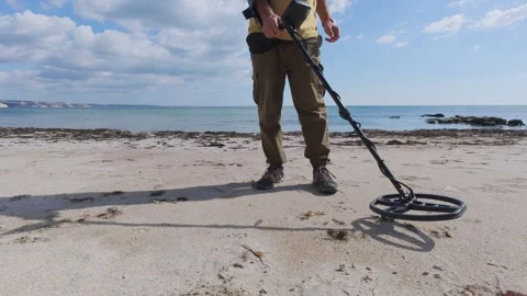 Man using metal detector on sandy beach near the sea, close-up view of legs and Stock Footage 318875210